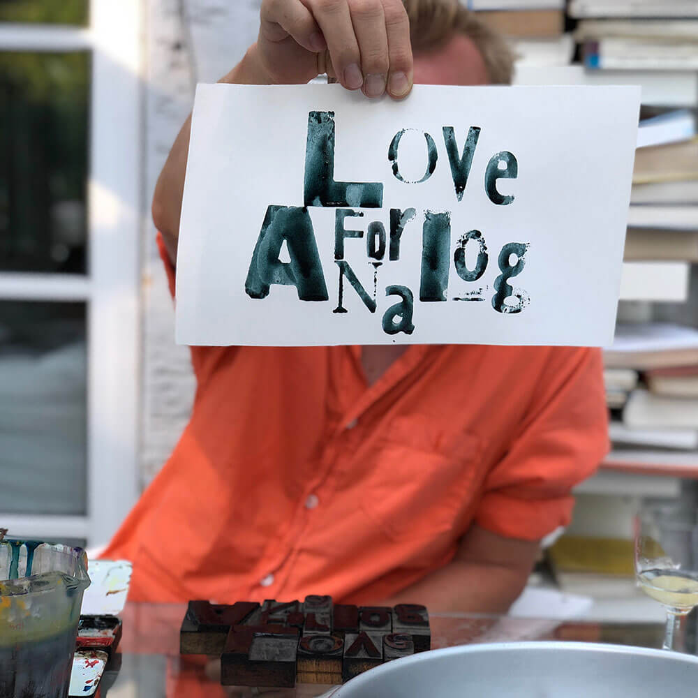 Frido holding up the Love for Analog print created from letterpress